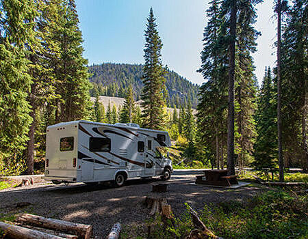beautiful-campsite-mountains-with-rv-wooden-bench